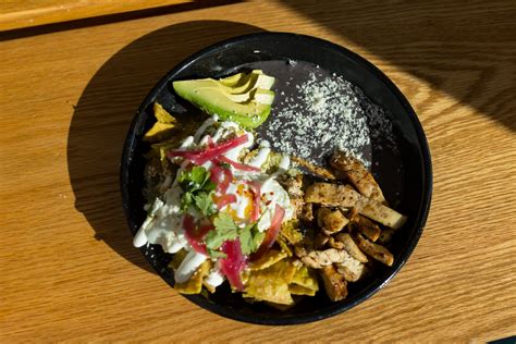 All Chilaquiles served with pickled onions, cilantro, crema, Queso Fresco, avocado, chili fried eggs and refried beans. . Chilaquiles buen dia photos